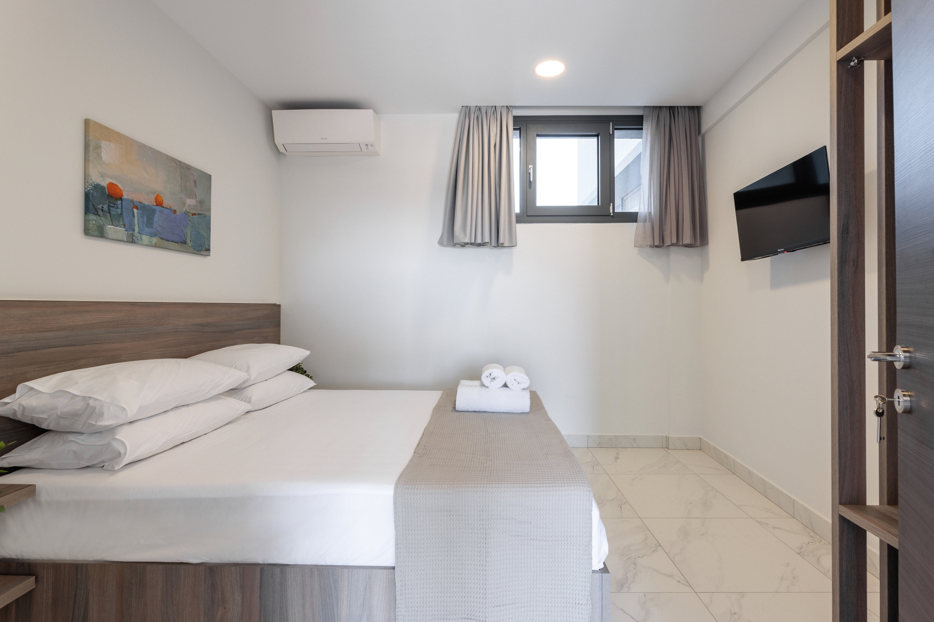 a room with a bed and a tv on the wall