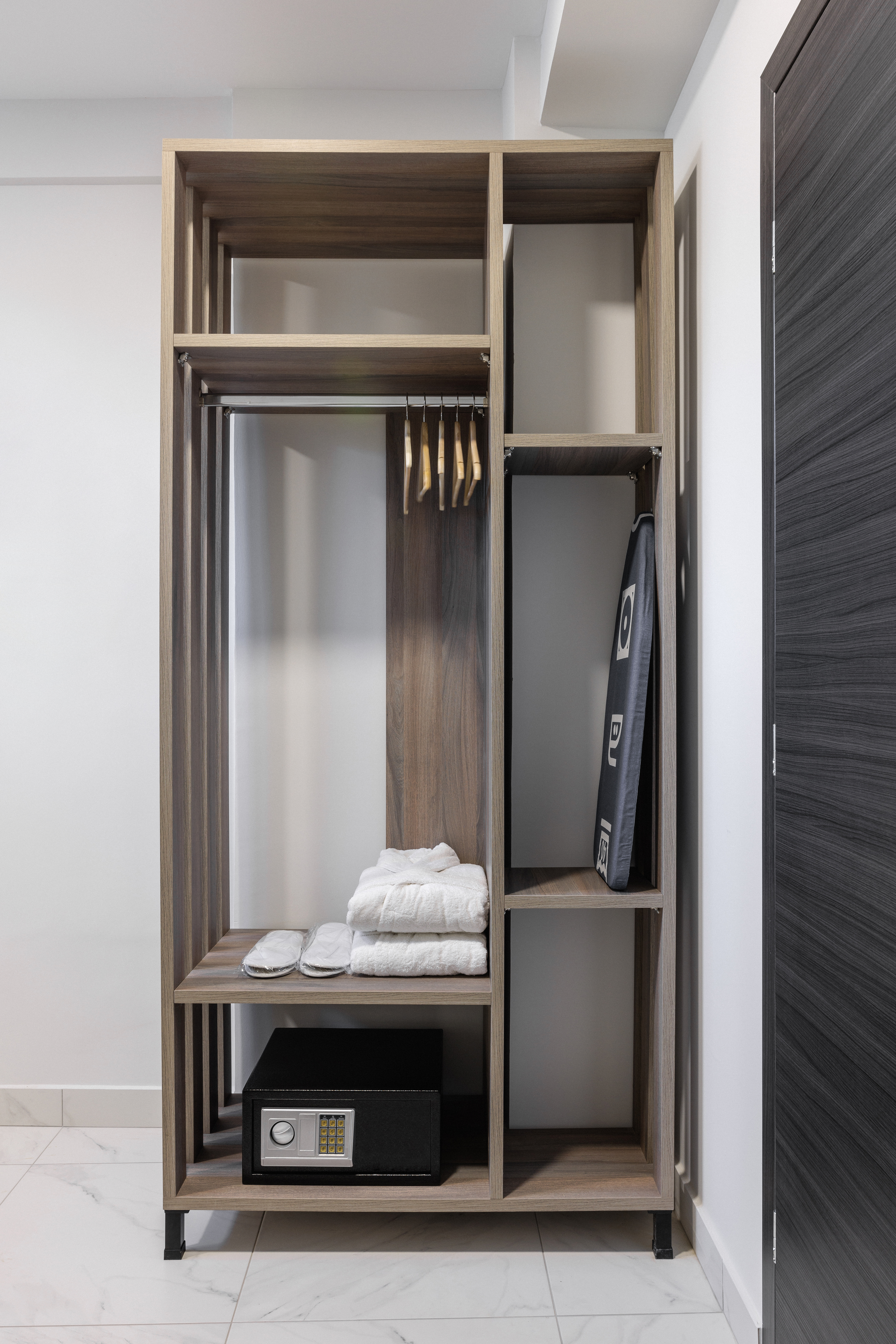 a closet with a mirror and a shelf with towels