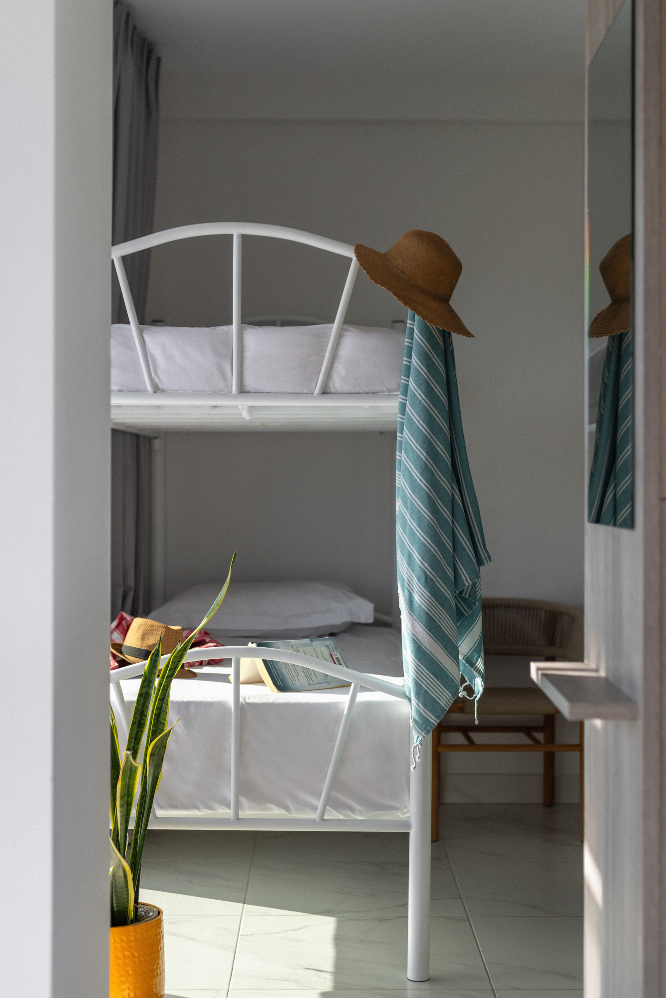 a bed with a green and white striped blanket and a white bed