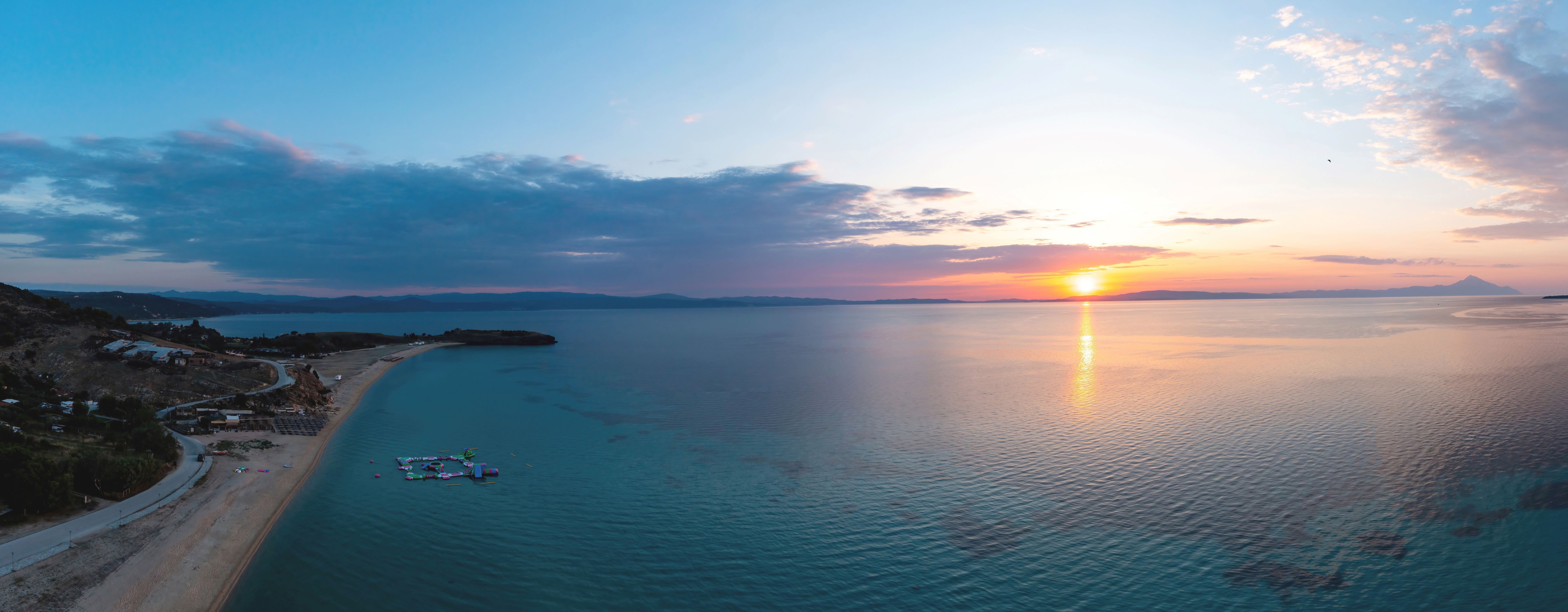 a body of water with land and a beach in the background